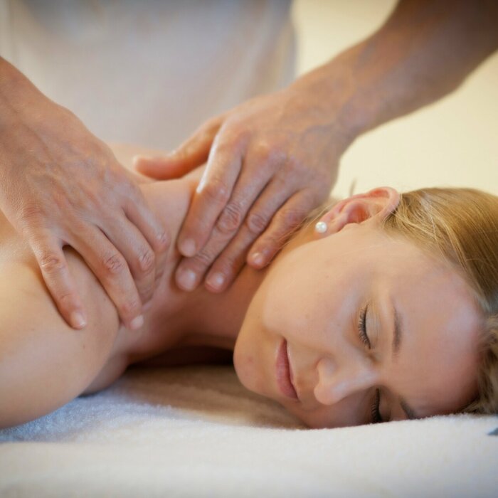 Frau liegend während sie an den Schultern massiert wird