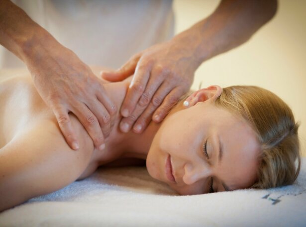 Frau liegend während sie an den Schultern massiert wird