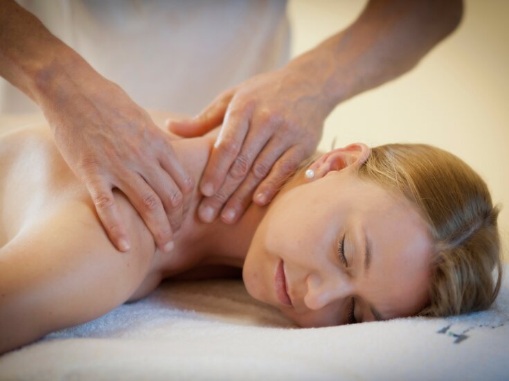 Frau liegend während sie an den Schultern massiert wird