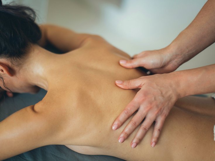 Frau liegend während klassischer Rückenmassage