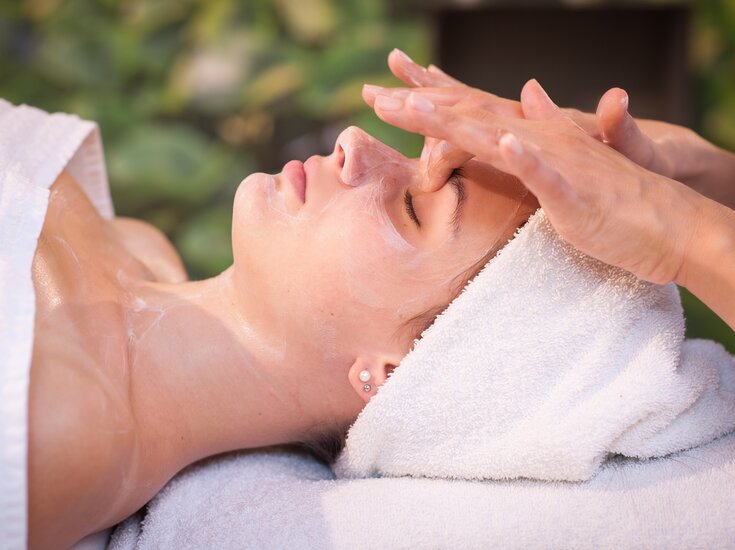 Frau liegend während Gesichtsbehandlung